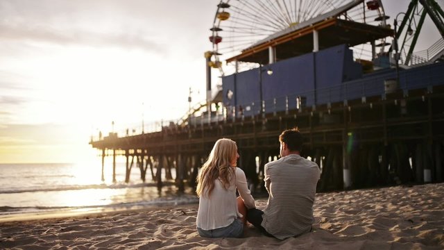romantic couple watching sunset at santa monica