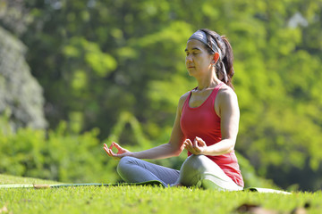 Middle aged woman doing yoga posture outdoor