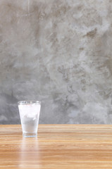 glass of water on table in front of wall