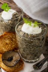 Mushroom pate in a jar over dark background, selective focus,