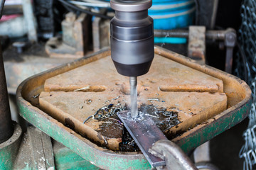 Close up industrial technician working on a drilling machine