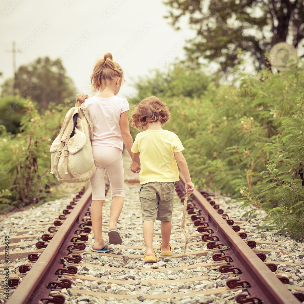 Canvas Prints two little kids with backpack standing on the railway