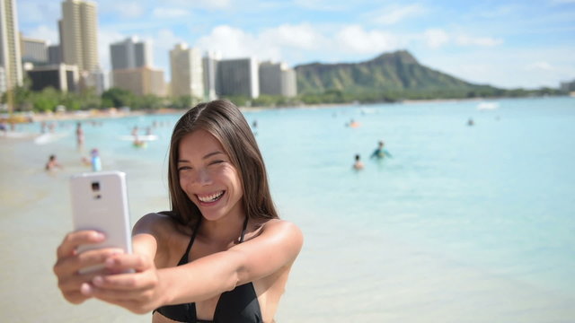 Beach bikini woman taking Selfie with smart phone