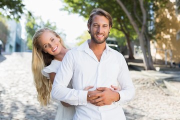 Fototapeta premium Attractive couple hugging each other and smiling at camera