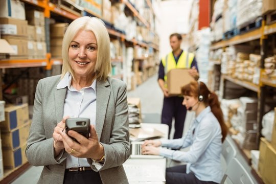 Smiling warehouse manager using handheld