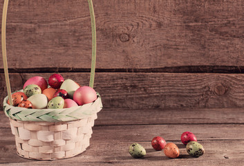 easter eggs in basket on wooden background