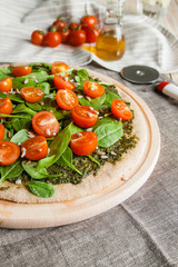 Fototapeta na wymiar Pizza with pesto, spinach and cherry tomatoes