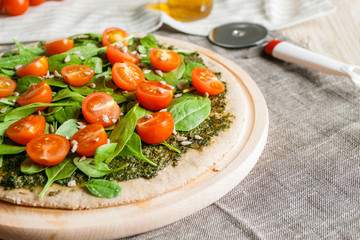 Pizza with pesto, spinach and cherry tomatoes