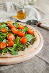 Pizza with pesto, spinach and cherry tomatoes