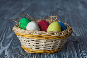 Easter egg basket. Vintage gray wood background. (Soft focus)