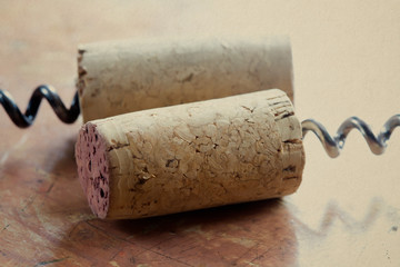 Two corkscrew with wine corks. Paper texture background.