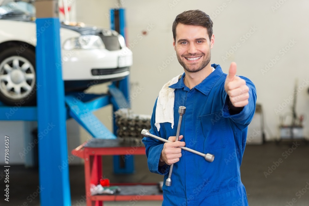 Poster smiling mechanic looking at camera