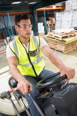Fototapeta premium Driver operating forklift machine in warehouse