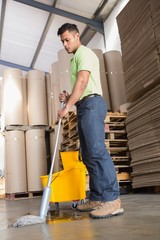 Focused man moping warehouse floor