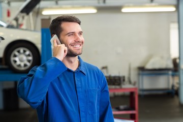 Smiling mechanic on the phone