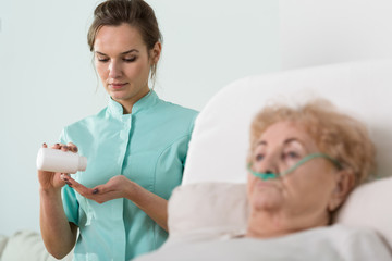 Ill senior woman and nurse