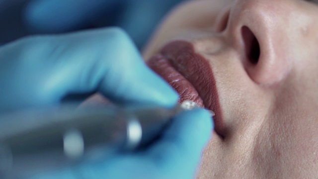 Close up of woman getting permanent lips makeup at beauty salon