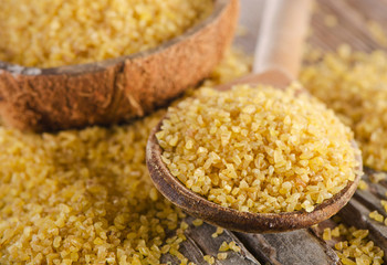 Bulgur in  wooden spoon on   wooden background