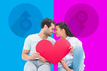 Composite image of cute couple sitting holding red heart