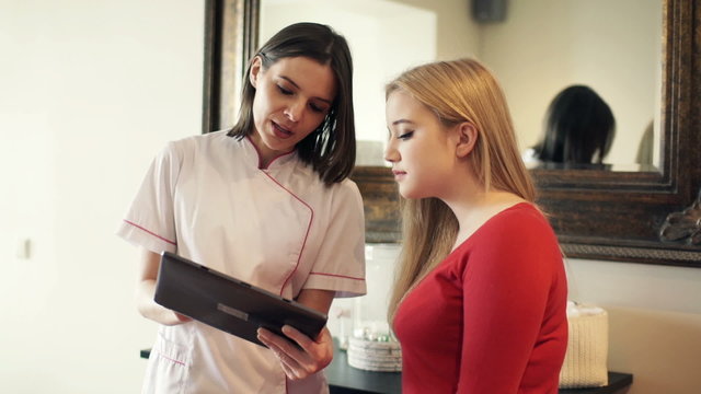 Woman with tablet computer explaining something to client