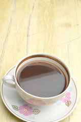 Coffe cup with floral ornament on a wooden table