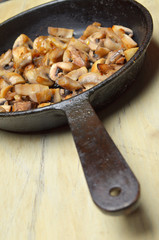Delicious fried mushrooms in pan on table