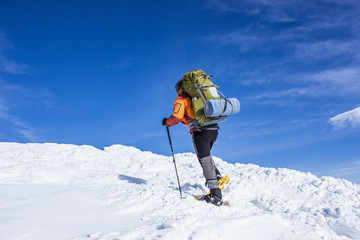 Winter hiking in the mountains on snowshoes .