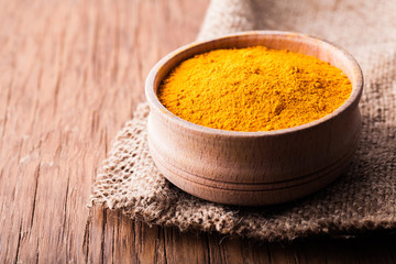 dry spice turmeric in a wooden bowl close-up