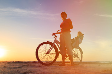 mother and baby biking at sunset