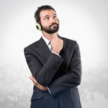 Young businessman listening music over white background
