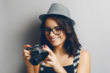 Beautiful girl in a hat with camera.