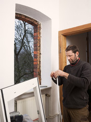 Carpenter mounting a new window