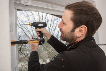 Carpenter mounting a new window