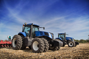 Fototapeta premium Two tractor drills in the field
