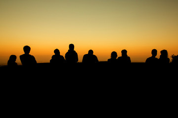 Fototapeta na wymiar silhouette of group of friends standing in sunset