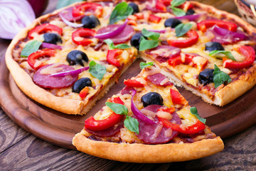 Delicious pizza served on wooden table