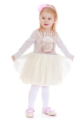 Beautiful little girl clings to her dress.