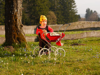 Kind mit Puppenwagen
