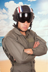 young handsome pilot wearing uniform and helmet over beach