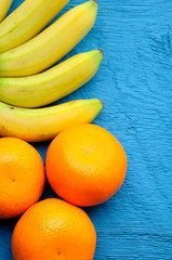baby bananas and oranges on blue wooden background