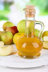 Apple cider vinegar in glass bottle and ripe fresh apples,