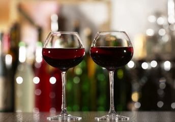 Two glasses of wine with bar on background