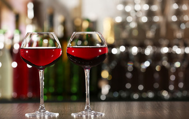 Two glasses of wine with bar on background