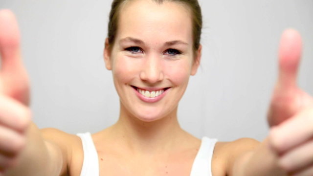 Junge Frau zeigt Daumen hoch
