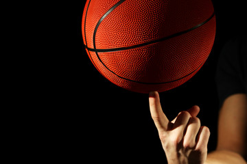 Basketball player holding ball, on dark background