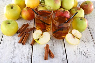 still life with apple cider and fresh apples on wooden table
