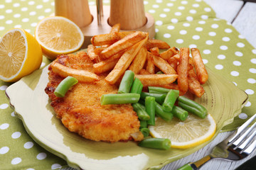 Breaded fried fish fillets and potatoes with asparagus and
