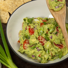 Guacamole with green onions and nachos. Selective focus.