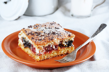 Homemade pie with jam and glass of milk on tablecloth