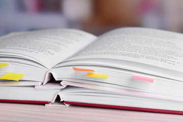 Books with bookmarks on table on bright background